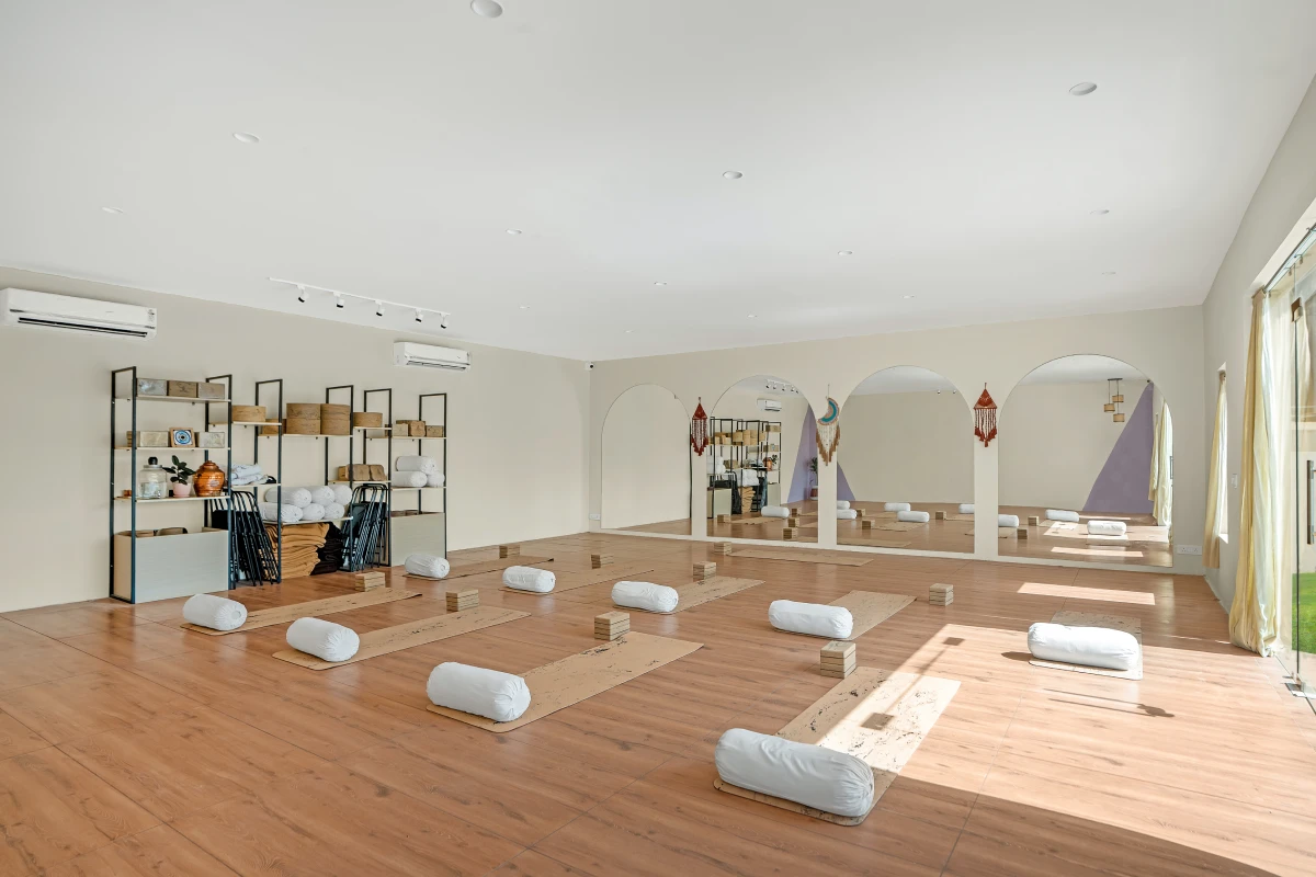 The main yoga hall with wooden floors and arched windows